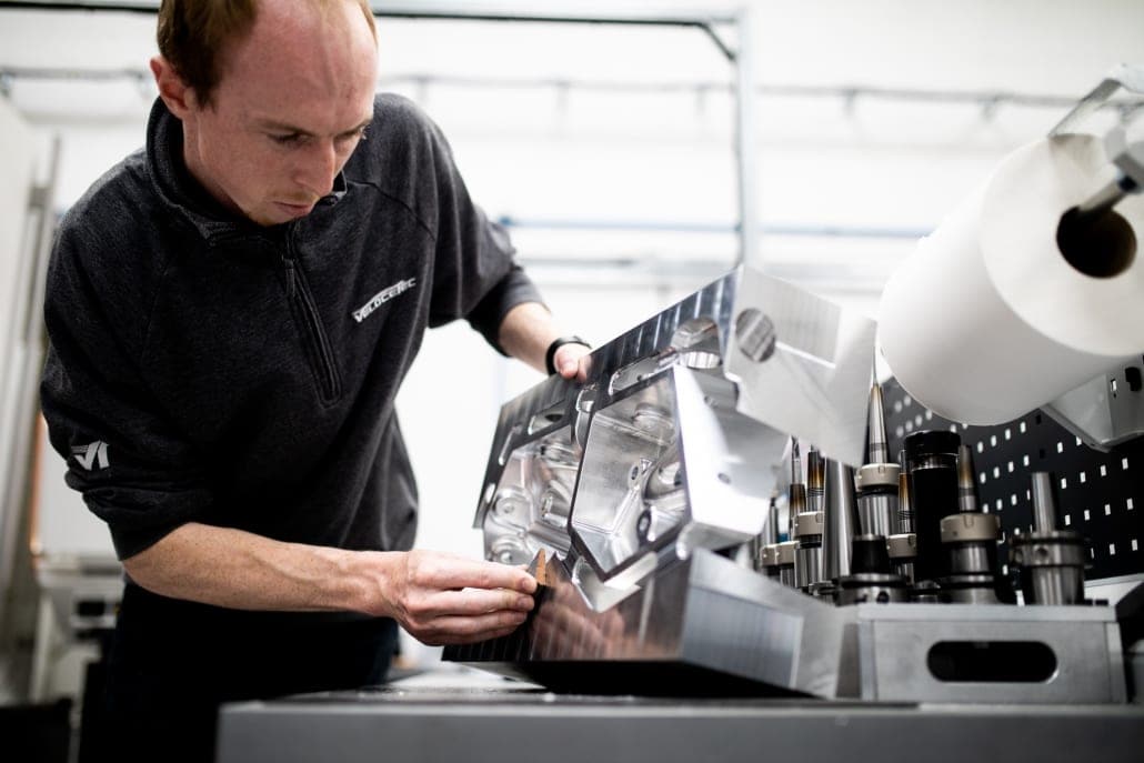 Photo of a Velocetec team member finishing a part